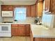 Well-lit kitchen showcases classic wooden cabinets, white appliances, and neutral countertops for a traditional feel at 6105 E St Joseph St, Indianapolis, IN 46219