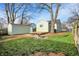 A view of a fenced backyard with a detached garage, wood deck, and fire pit at 621 Melvenia St, Indianapolis, IN 46219