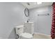A bathroom with vinyl flooring, modern toilet, and cabinet sink with a round mirror at 621 Melvenia St, Indianapolis, IN 46219