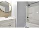 This bathroom features a tile backsplash, framed circular mirror, and shower and tub at 621 Melvenia St, Indianapolis, IN 46219