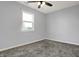 This carpeted bedroom features a ceiling fan and a window providing ample natural light at 621 Melvenia St, Indianapolis, IN 46219