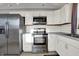Spacious kitchen with stainless steel appliances, white cabinets, and hardwood flooring with great lighting at 621 Melvenia St, Indianapolis, IN 46219