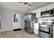 Bright kitchen with stainless steel appliances, white cabinets, and door to outdoor area with nice lighting at 621 Melvenia St, Indianapolis, IN 46219