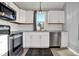 Well-lit kitchen with stainless steel appliances, white cabinets, and subway tile backsplash, hardwood floors at 621 Melvenia St, Indianapolis, IN 46219