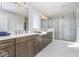 Bathroom with dual vanities, sleek cabinets, and a glass-enclosed shower, designed for modern comfort at 6609 N Dogwood Dr, McCordsville, IN 46055