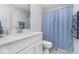 Bright bathroom featuring a white vanity with a quartz countertop and a shower with a blue curtain at 6609 N Dogwood Dr, McCordsville, IN 46055