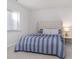 Comfortable bedroom featuring a tufted headboard, window and blue striped bedding at 6609 N Dogwood Dr, McCordsville, IN 46055