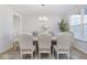 Elegant dining room with modern chandelier, neutral decor, and view of the backyard at 6609 N Dogwood Dr, McCordsville, IN 46055