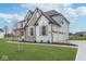 Attractive two-story home with an attached three-car garage, manicured lawn, and stone details at 6609 N Dogwood Dr, McCordsville, IN 46055