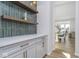 Stylish kitchen featuring tile wall, modern cabinets, countertops, and an open doorway to adjacent rooms at 6609 N Dogwood Dr, McCordsville, IN 46055