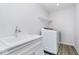 Bright laundry room with white cabinetry, stainless steel faucet, and white washer and dryer at 6609 N Dogwood Dr, McCordsville, IN 46055