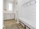 Bright mudroom with white cabinetry, wood floors, shiplap accent wall, and convenient built-in bench at 6609 N Dogwood Dr, McCordsville, IN 46055