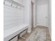 Mudroom featuring built-in bench with storage, coat hooks, and light wood-look flooring at 6609 N Dogwood Dr, McCordsville, IN 46055