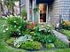 Charming home exterior with colorful flowers, lush greenery, and a welcoming entrance at 7160 Harbour, Indianapolis, IN 46240