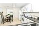 Compact kitchen featuring white cabinets, modern appliances, and a cozy dining area at 7160 Harbour, Indianapolis, IN 46240