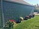 Side of the house with potted mums, colorful flowers, and lush green lawn at 7160 Harbour, Indianapolis, IN 46240