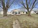 Scenic backyard with established trees, stone pathway, and screened-in porch at 7228 Muirfield Pl, Indianapolis, IN 46237