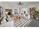 Bright living room with stone fireplace, ceiling fan, neutral colored furniture, and access to sunroom at 7228 Muirfield Pl, Indianapolis, IN 46237