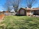 Spacious backyard features a well-maintained lawn, wooden fence, and partial brick exterior at , Indianapolis, IN 46217