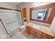 Well-lit bathroom featuring a shower, toilet, sink, vanity, and mirror with a decorative frame at 802 Burwick Trce, Greenwood, IN 46143