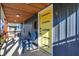 Inviting front porch with seating, complemented by a bright yellow door, creating a welcoming entrance at 934 E Minnesota St, Indianapolis, IN 46203