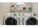 Functional laundry room featuring modern washer and dryer units, and shelving at 934 E Minnesota St, Indianapolis, IN 46203