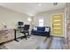 Bright office featuring a modern desk, blue sofa, neutral walls, and a striking yellow door at 934 E Minnesota St, Indianapolis, IN 46203