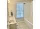 Bathroom featuring a double sink vanity, window with blinds, shower/tub combo, and tiled floors at 12652 Meeting House Rd, Carmel, IN 46032