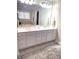 Bathroom featuring a double sink vanity, white cabinets, gold hardware, large mirror, and patterned rug at 12652 Meeting House Rd, Carmel, IN 46032