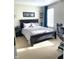 Bedroom featuring a dark wood bed frame, neutral walls and carpet, and large window with blue curtains at 12652 Meeting House Rd, Carmel, IN 46032