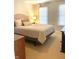 Bedroom featuring a beige bed frame and comforter, two windows with blinds, and an accent lamp at 12652 Meeting House Rd, Carmel, IN 46032