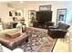 Relaxing living room showcasing tan sectional sofa, a leather ottoman, accent chairs, and decorative football memorabilia at 12652 Meeting House Rd, Carmel, IN 46032