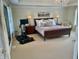 Relaxing main bedroom featuring a workout area, chandelier, neutral walls and carpet, and a large bed with throw pillows at 12652 Meeting House Rd, Carmel, IN 46032