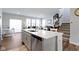 Kitchen with island, stainless dishwasher, and seating looking out to the living room at 13783 Tender Dr, Carmel, IN 46032
