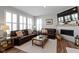 Inviting living room with leather sofas, fireplace, and natural light from shuttered windows at 13783 Tender Dr, Carmel, IN 46032