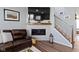 Comfortable living area with fireplace and mounted television, adjacent to staircase at 13783 Tender Dr, Carmel, IN 46032