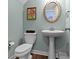 Charming powder room features a pedestal sink, decorative mirror, and soft blue walls at 13783 Tender Dr, Carmel, IN 46032