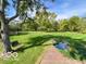 Beautiful backyard with mature trees, well-manicured lawn, and a charming pond feature at 1402 Hornaday Rd, Brownsburg, IN 46112