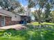 Large backyard features a patio, a pond, a screened-in porch, mature trees and lush green grass at 1402 Hornaday Rd, Brownsburg, IN 46112