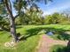 Picturesque backyard features a well-maintained lawn, mature trees, and a serene pond area at 1402 Hornaday Rd, Brownsburg, IN 46112