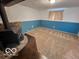 Empty basement with blue paneling and an energy efficient fireplace waiting to be re-designed at 1402 Hornaday Rd, Brownsburg, IN 46112