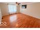 Spacious bedroom features hardwood floors, ceiling fan and light fixture, and a large window with coverings at 1402 Hornaday Rd, Brownsburg, IN 46112