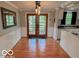 Dining room features hardwood flooring, wainscotting, a statement light fixture, and view to the backyard at 1402 Hornaday Rd, Brownsburg, IN 46112