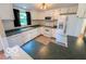 White kitchen offers bright natural light, white appliances, tile flooring, and plenty of countertop space at 1402 Hornaday Rd, Brownsburg, IN 46112