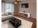 Living room with wood floors, couch, modern coffee table, television, and neutral colored walls at 1402 Hornaday Rd, Brownsburg, IN 46112