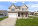 Charming two-story home with a well-manicured lawn and a two car garage and covered porch at 15152 Fallen Leaves Ln, Noblesville, IN 46060