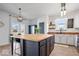Modern kitchen with large island, updated lighting, white cabinets, and a black door to pantry at 15152 Fallen Leaves Ln, Noblesville, IN 46060