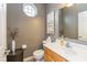 Stylish half bathroom with modern decor, wooden cabinets, decorative mirror, and bright lighting at 15885 Symphony Blvd, Noblesville, IN 46060