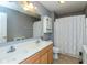 This bathroom features a large mirror, double sink vanity, and a shower/tub combo with a white shower curtain at 15885 Symphony Blvd, Noblesville, IN 46060