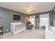 This bedroom has grey walls, carpet flooring, and a white crib, ceiling fan, and accent chair at 15885 Symphony Blvd, Noblesville, IN 46060